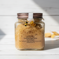 Glass jar of golden toasted sugar turbinado scrub with bee charm and honeycomb decoration